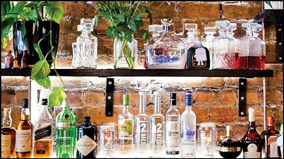 An assortment of bottles behind the bar at a local bar.