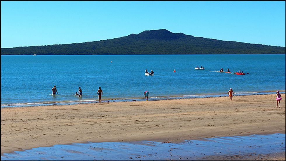 Various recreational activities in progress on the bitch looking towards a distant hill.