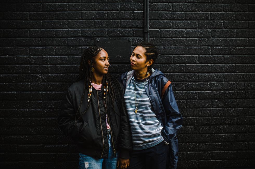 Two young queer women in a relationship.