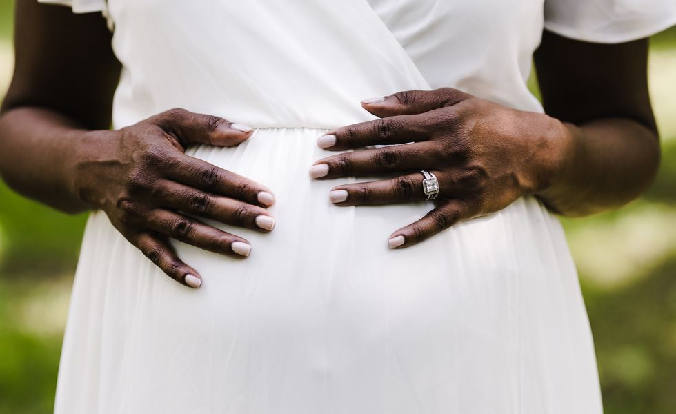 Pregnant African bride in a white dress.