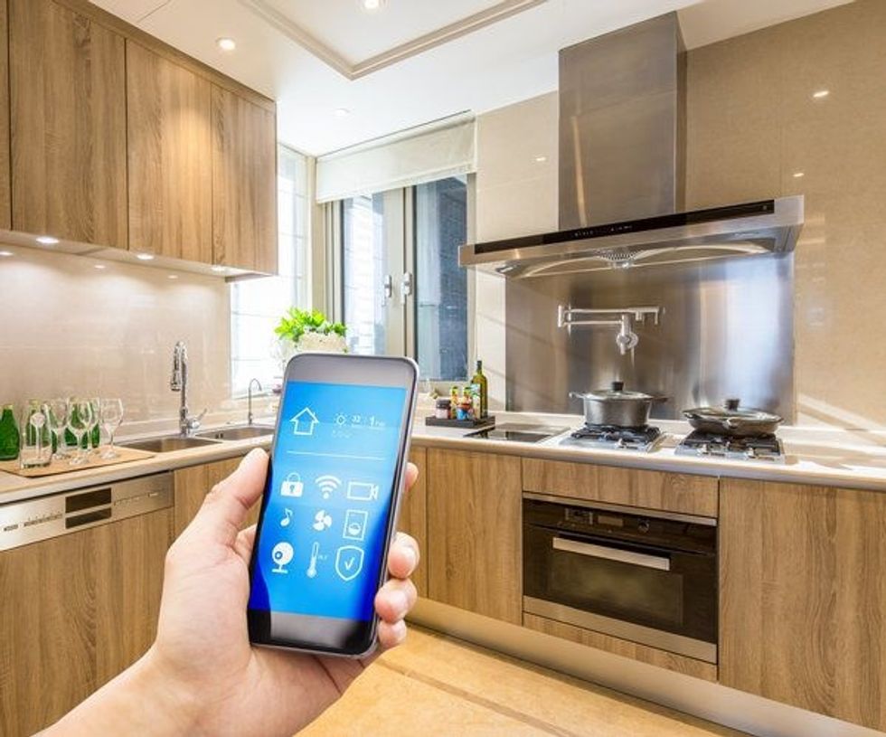 A smartphone controlling smart home devices in a kitchen