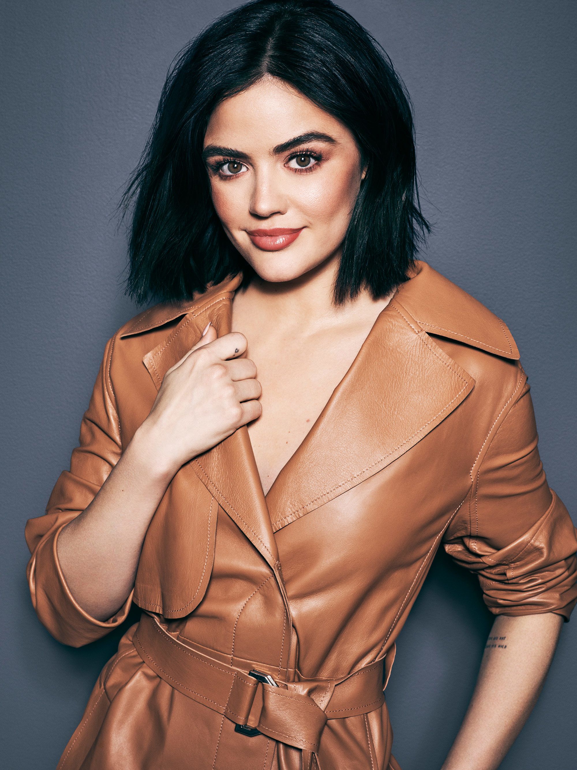 Lucy Hale in a brown leather trenchcoat.