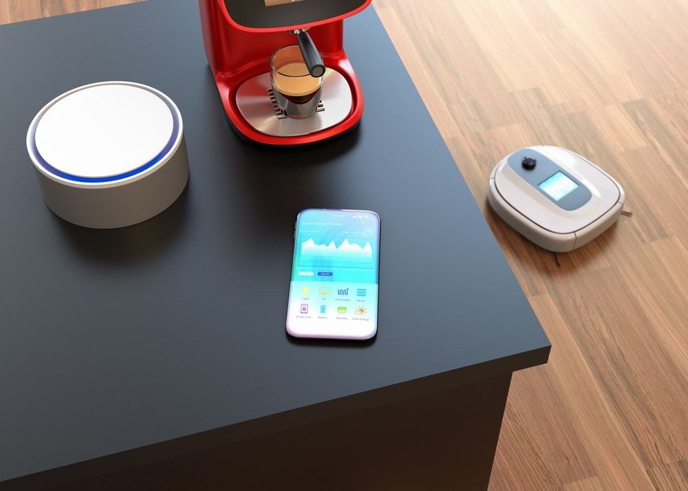 A smartphone on a table with a robot vacuum cleaner below
