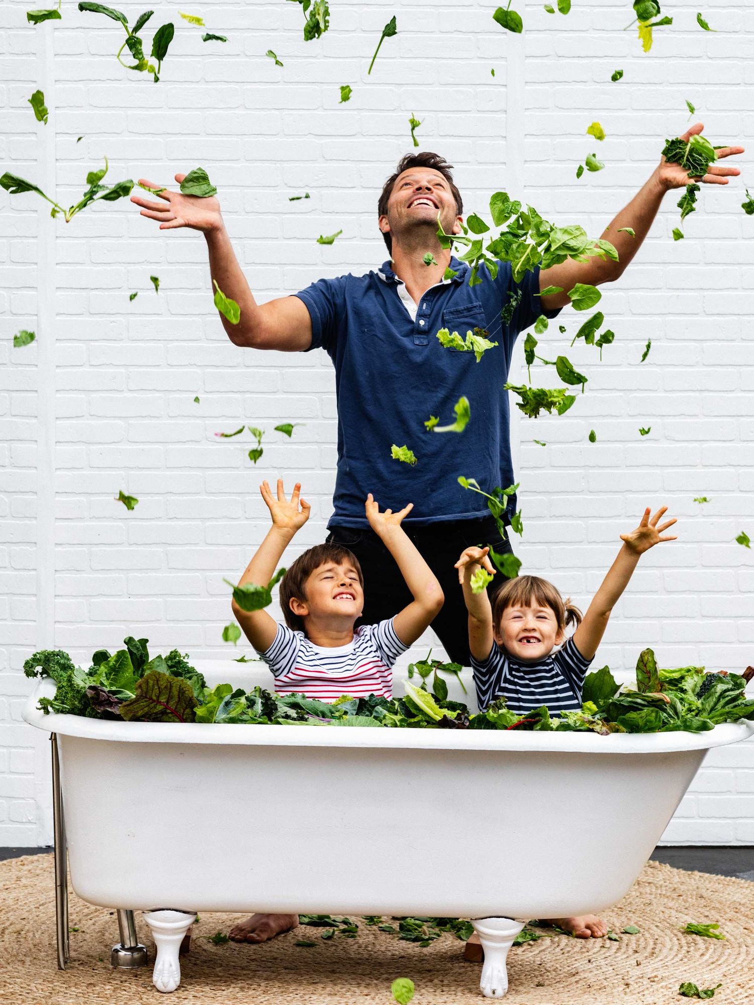 Misha Collins and kids tossing lettuce leaves in the air.