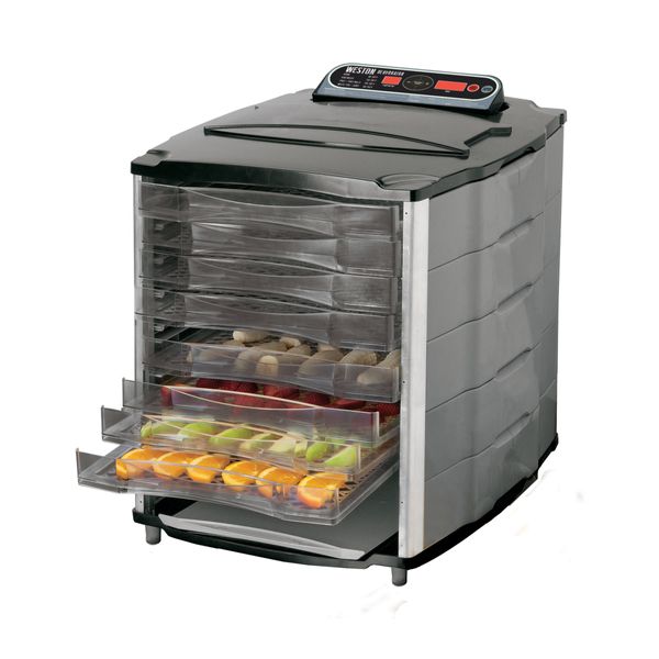 Food dehydrator with trays of fresh fruit slices.