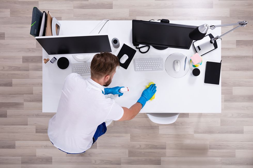 Man cleans and organizes his desk at work using the KonMari method
