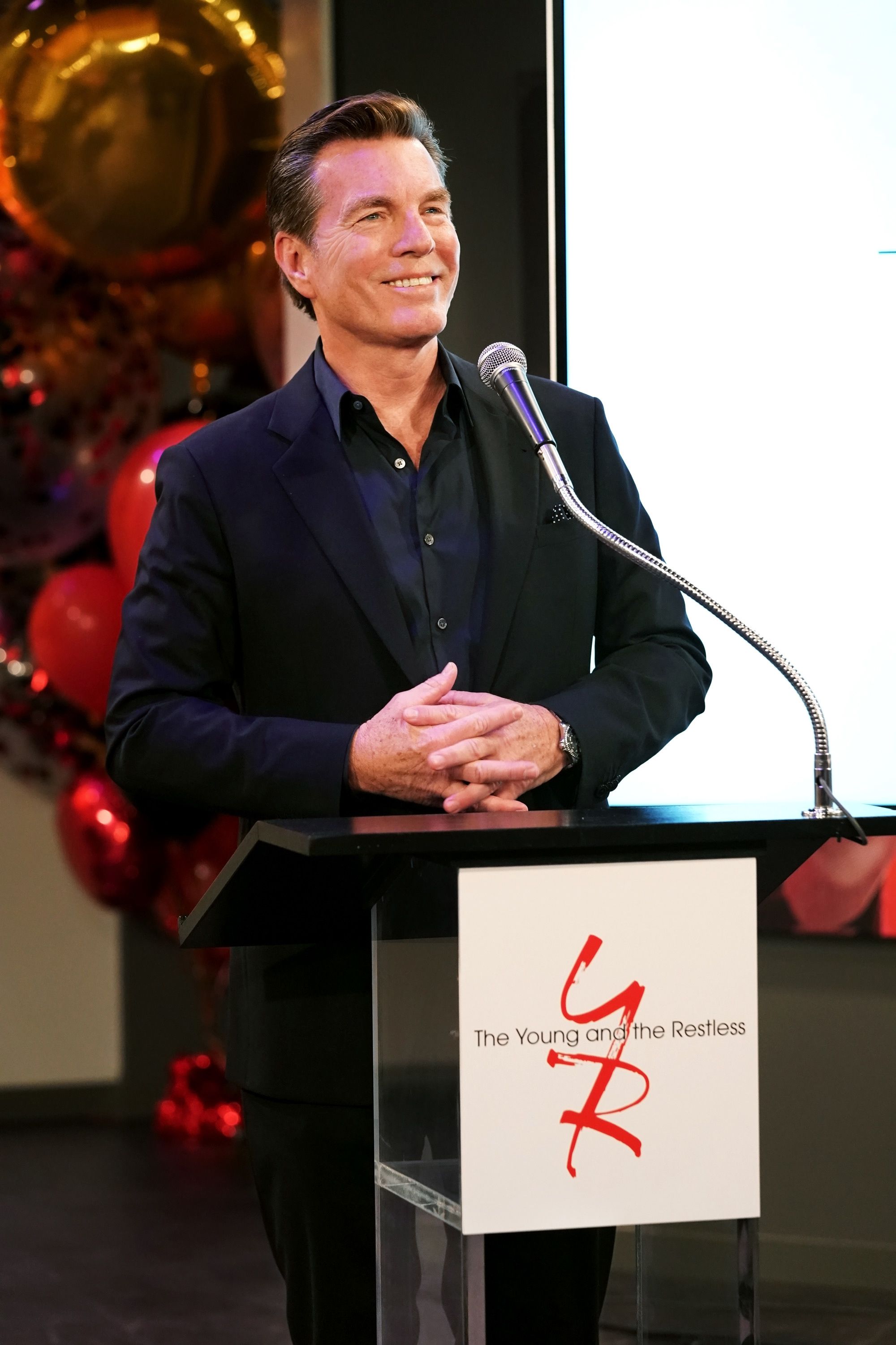 Peter Bergman at a podium giving a speech.