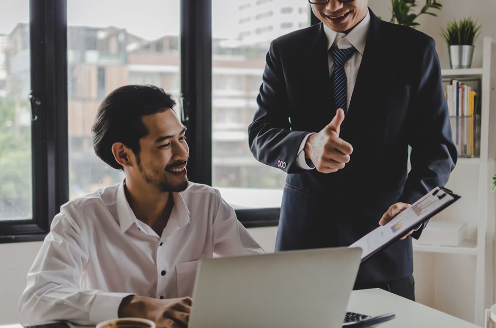 A manager thanks his employee for putting together a packet of data.