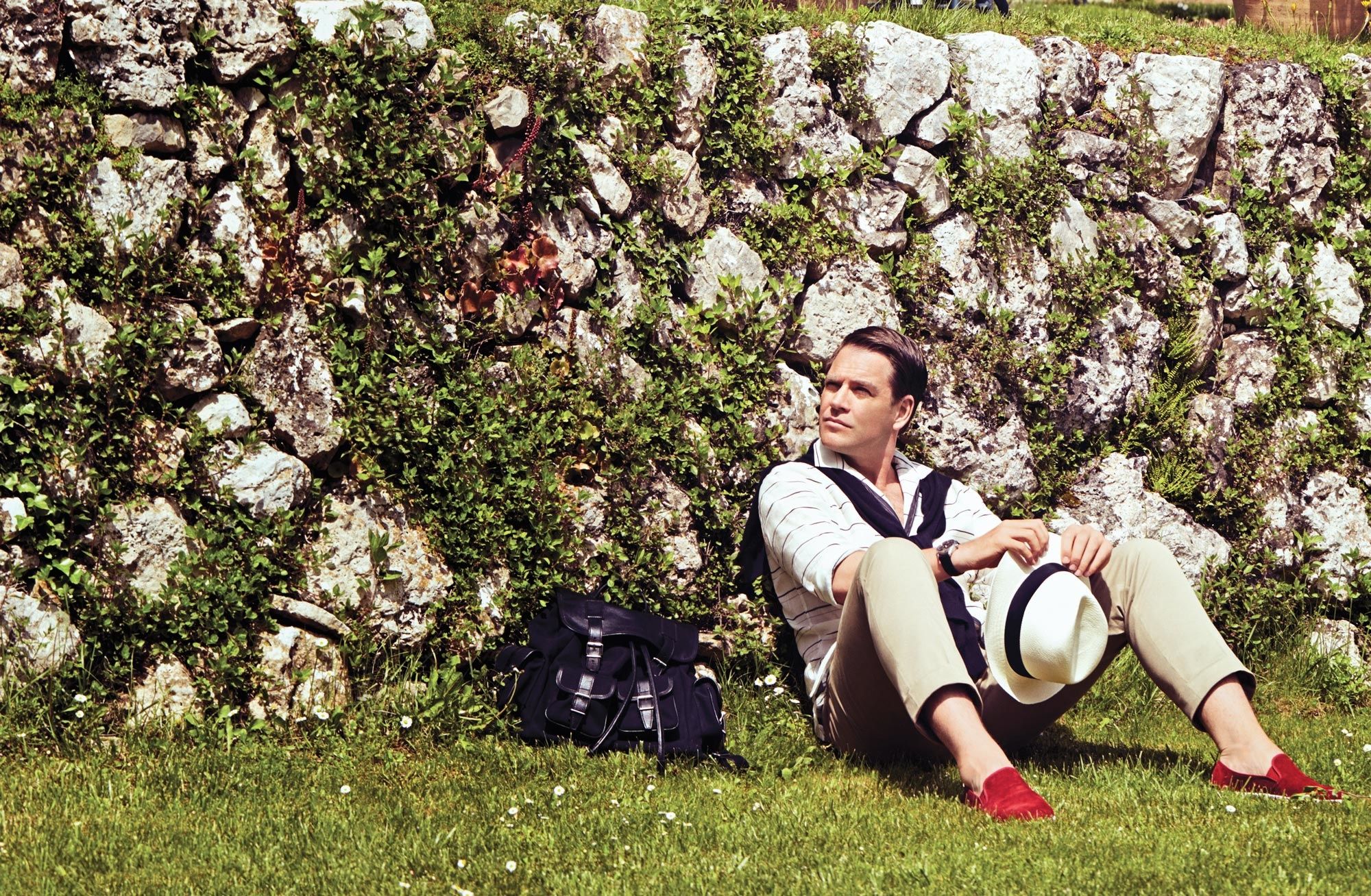 Michael Weatherly of Bull with red shoes sitting on grass