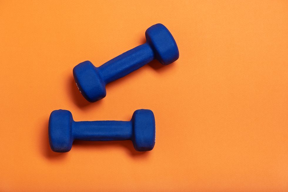 Pair of blue dumbbells Isolated on orange background.