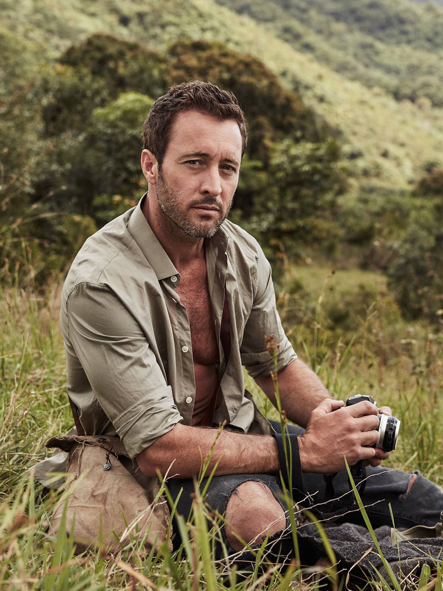 Alex O'Loughlin outside holding a camera