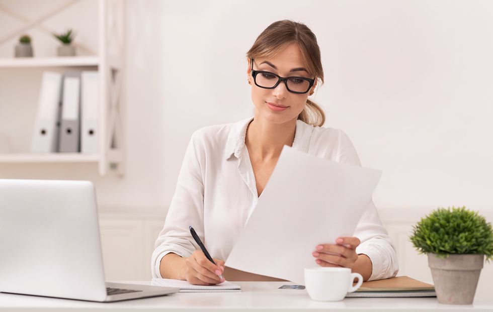 Woman looks at tax forms for her digital business