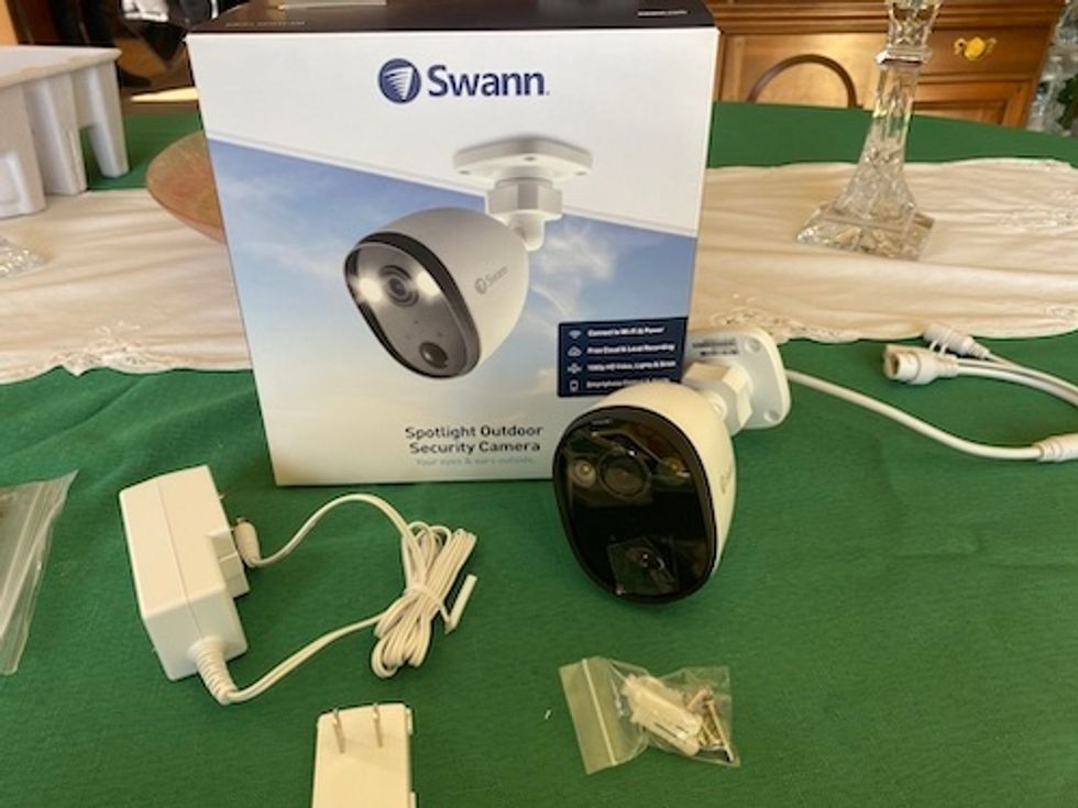 Swann Spotlight Outdoor Camera unboxed on a table.