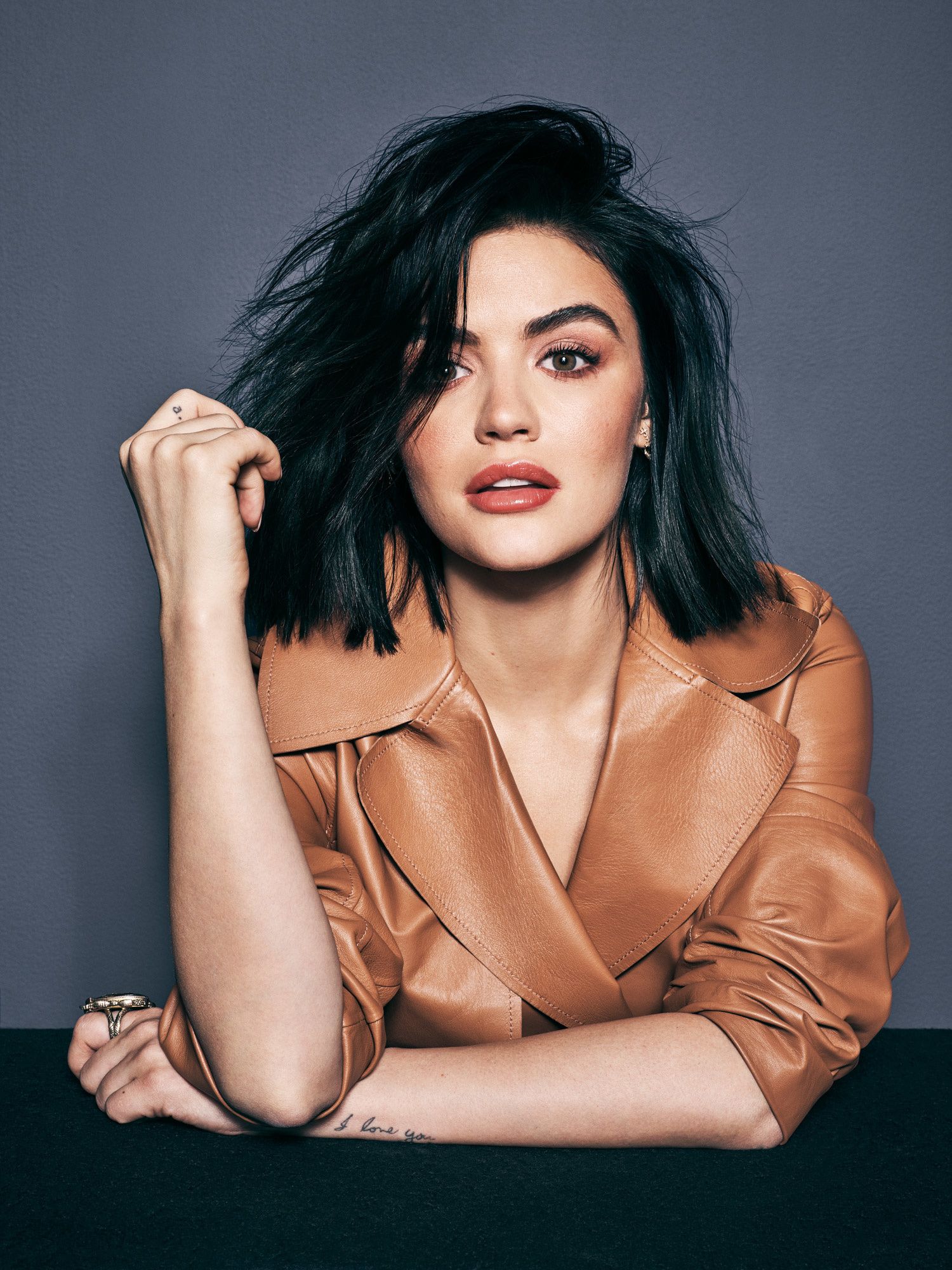 Lucy Hale in a brown leather trench coat.