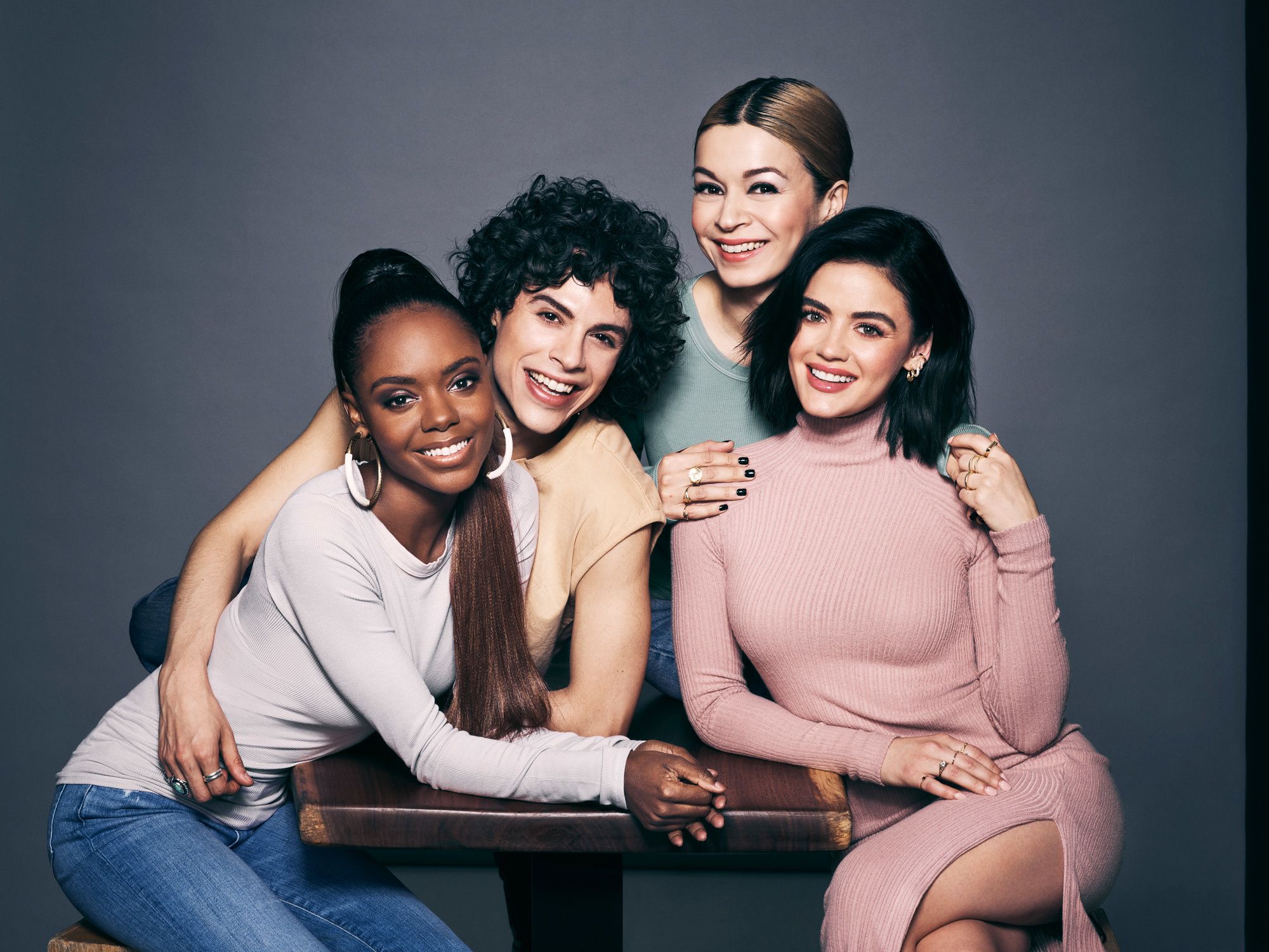 The cast of Katy Keene hugging and smiling.