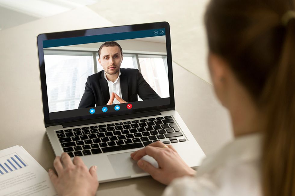 A business manager holds a video meeting with an employee.