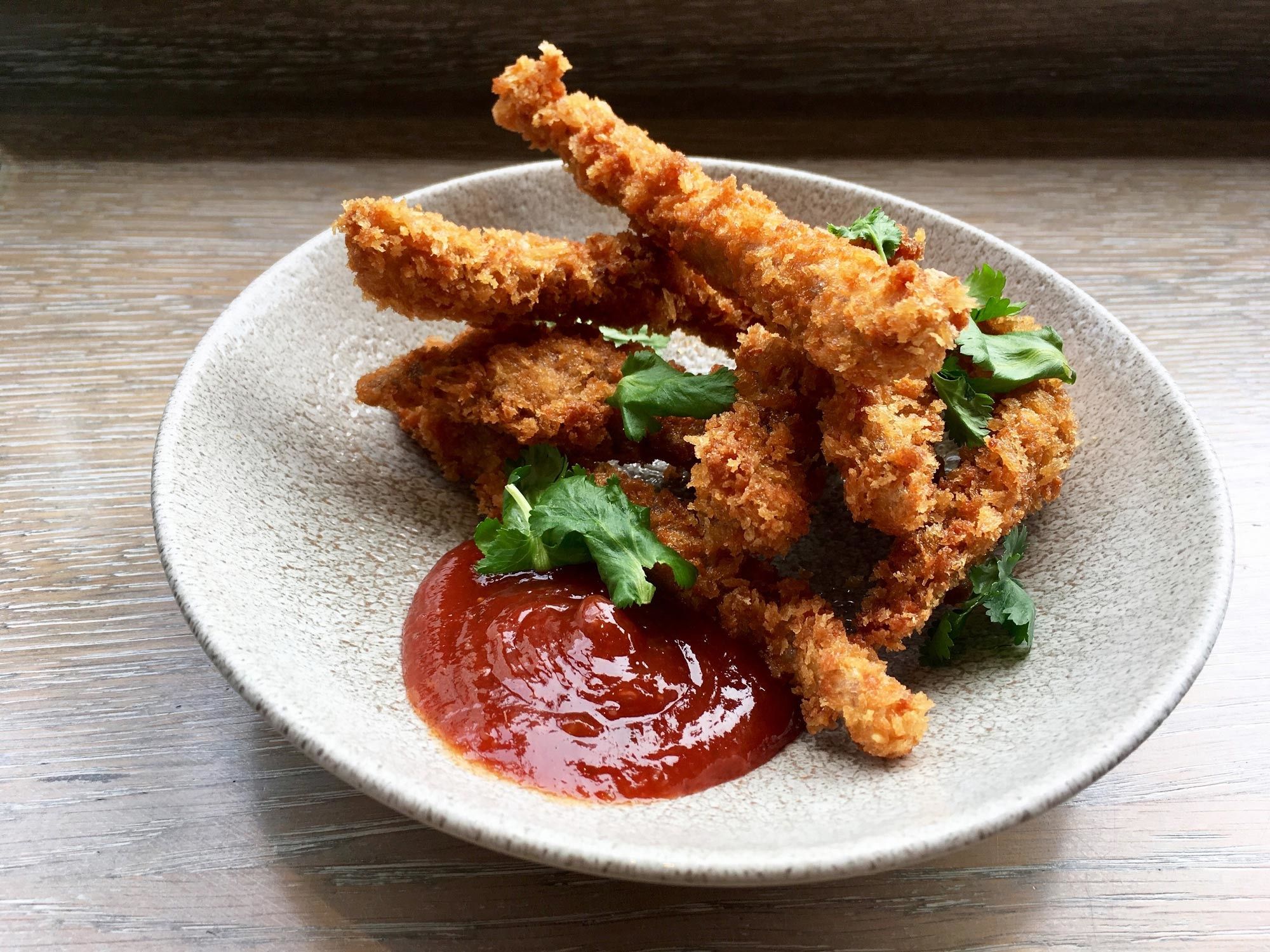 A plate of panko-crusted Japanese fried chicken tenders with yuzu, chili dipping sauce.