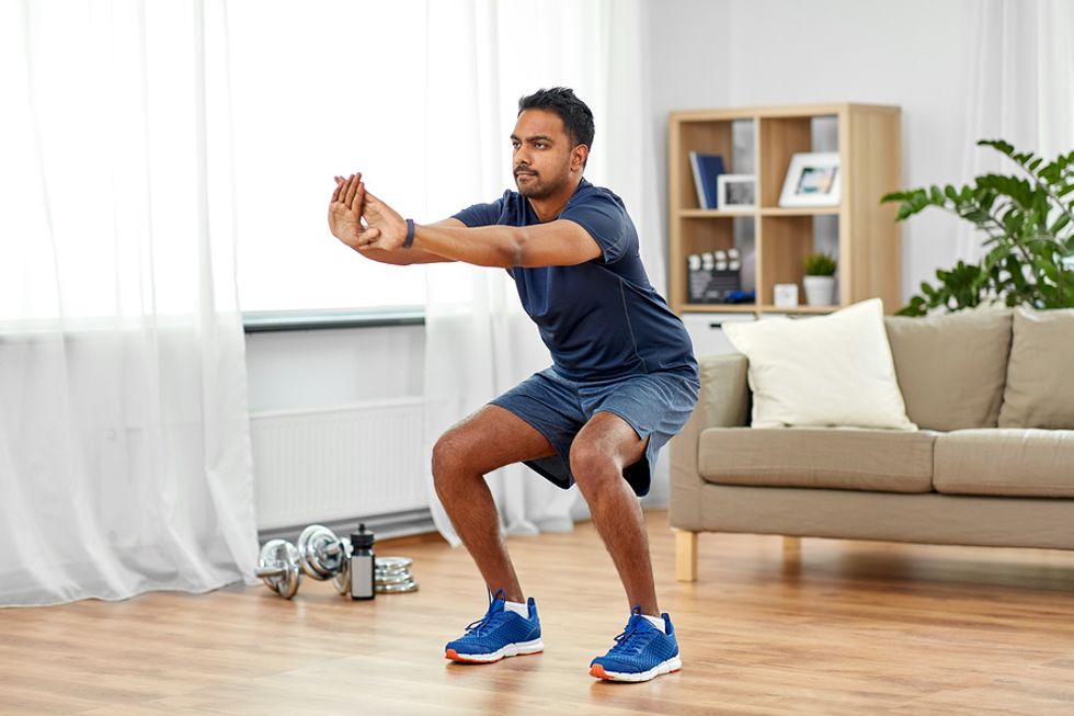 Man does squats during his home workout