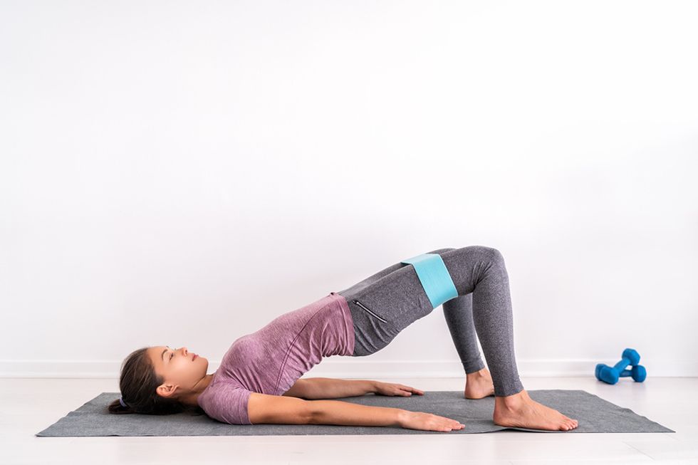Woman does a glute bridge while working out at home