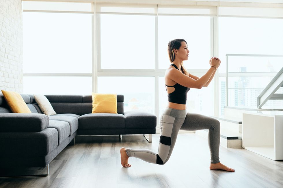 Woman does reverse lunges while doing a home workout