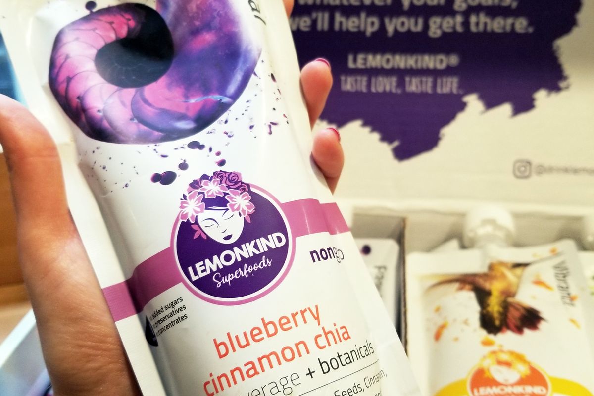 woman's hand holds picture of Blueberry Cinnamon Chia juice from Lemonkind