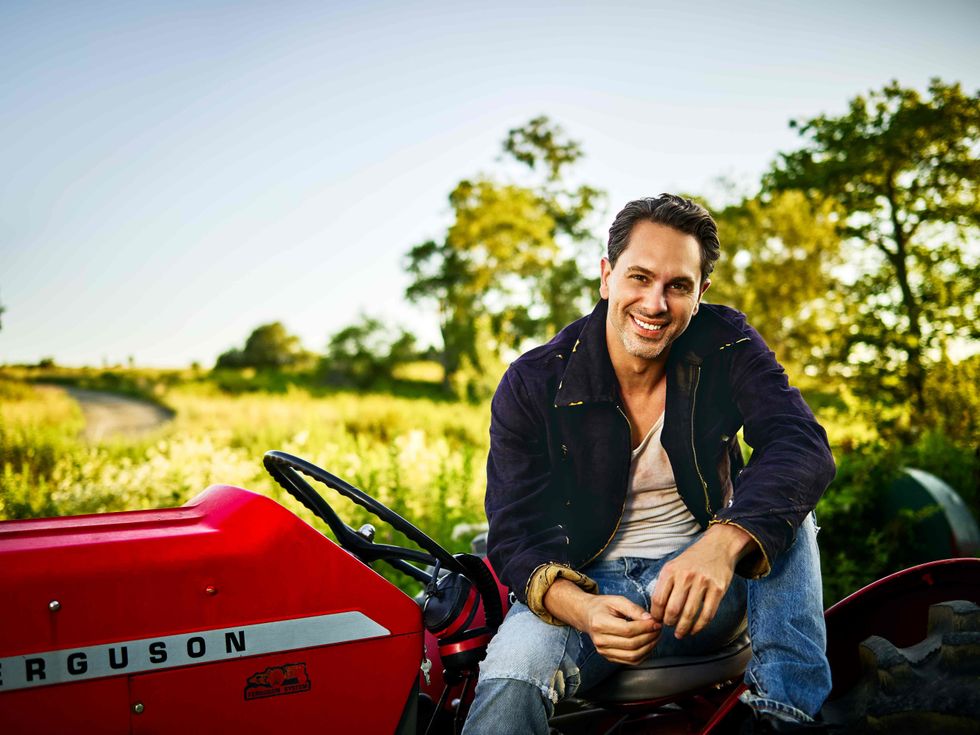 Thomas Sadoski sitting on a tractor.