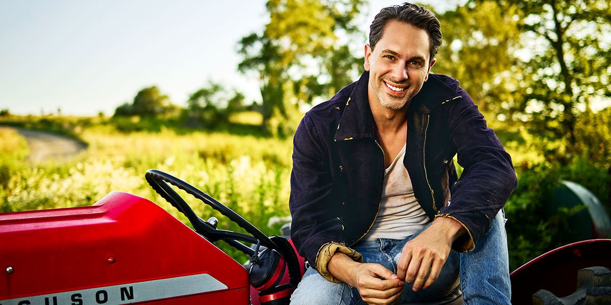 Actor Thomas Sadoski sitting on a tractor.