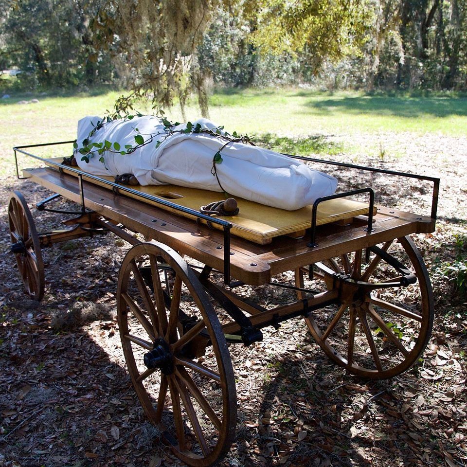 Wagon with shrouded body for natural burial.