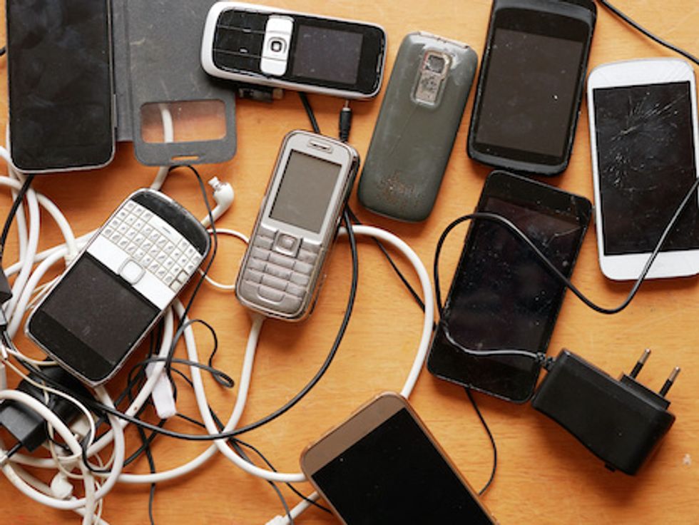 Cell phones and cables laying on the wooden board