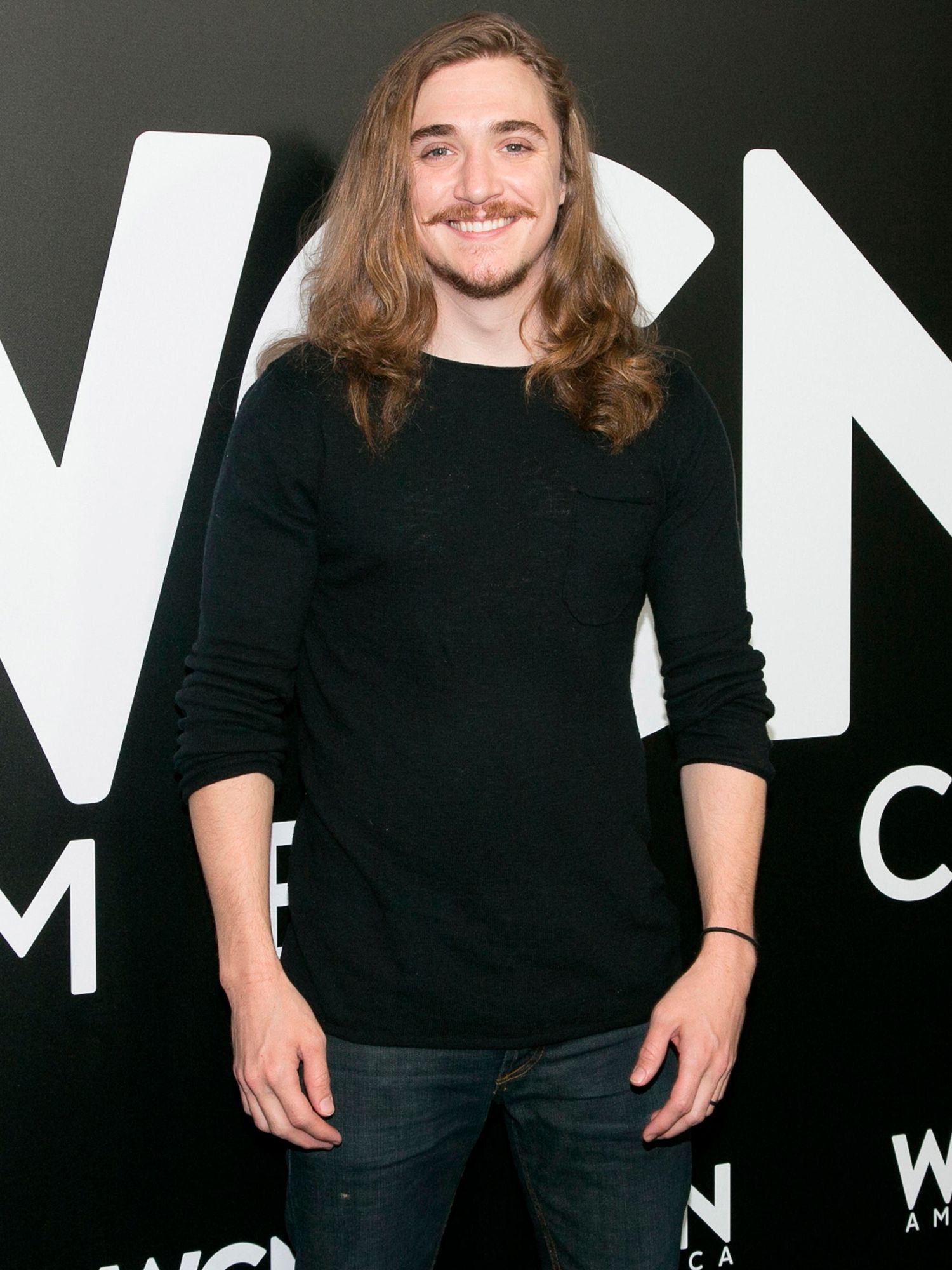 Actor Kyle Gallner in a black shirt and jeans.