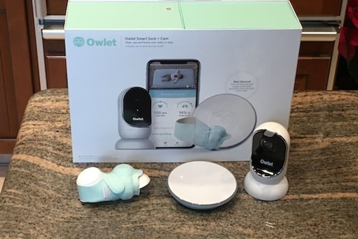 Owlet Sock and cam in the box on a counter.