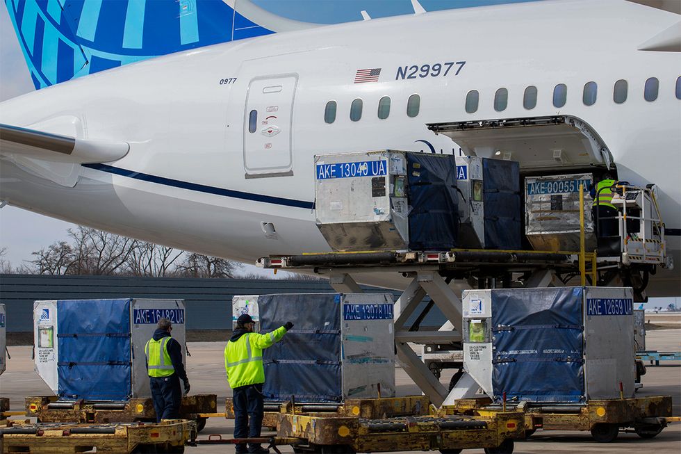 United ramp crew members help place cargo on a United flight