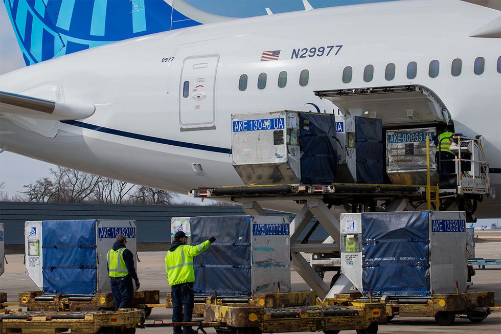 United ramp crew members help place cargo on a United flight 