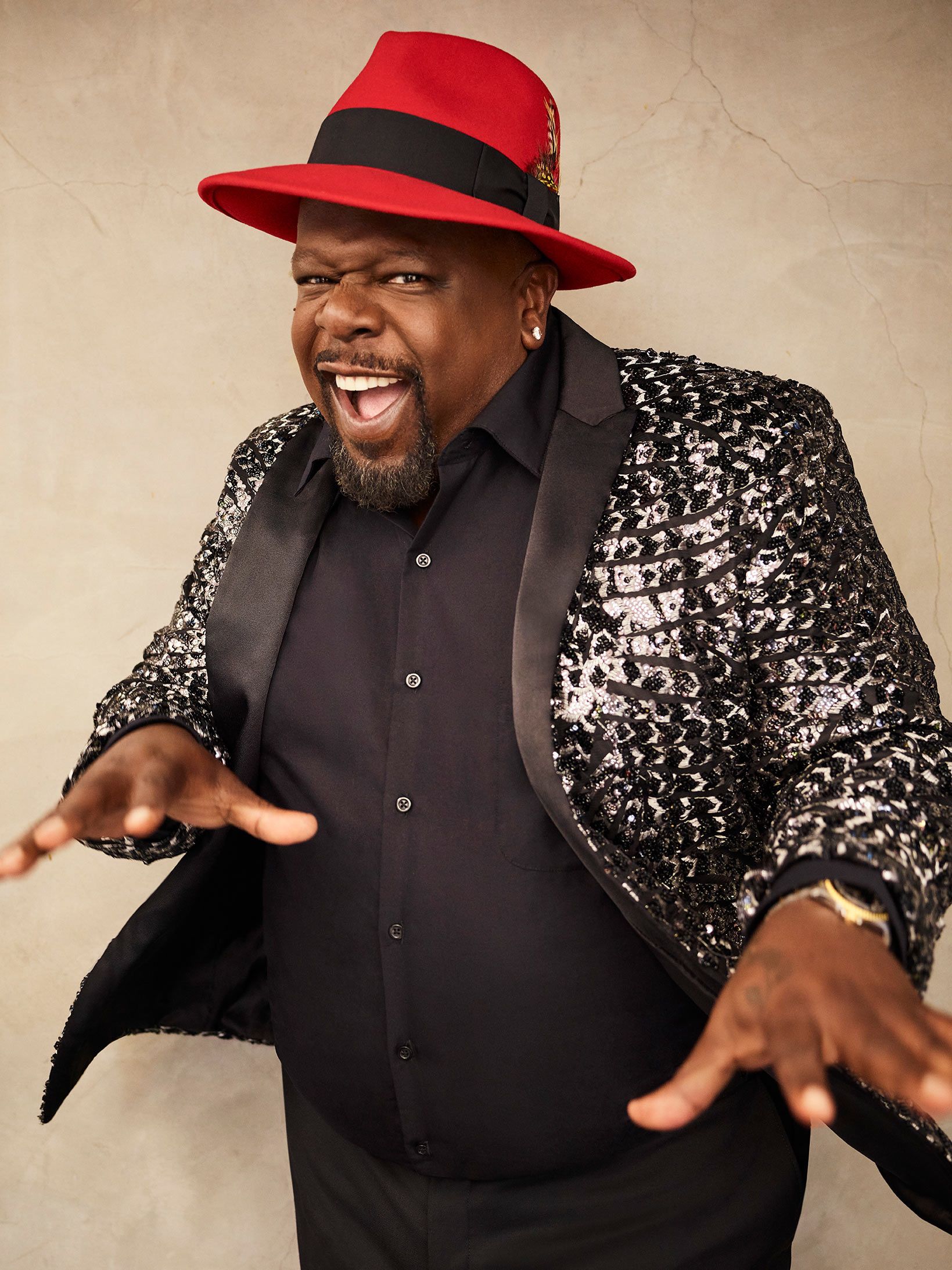 Cedric the Entertainer smiling and wearing a glittery sportscoat.