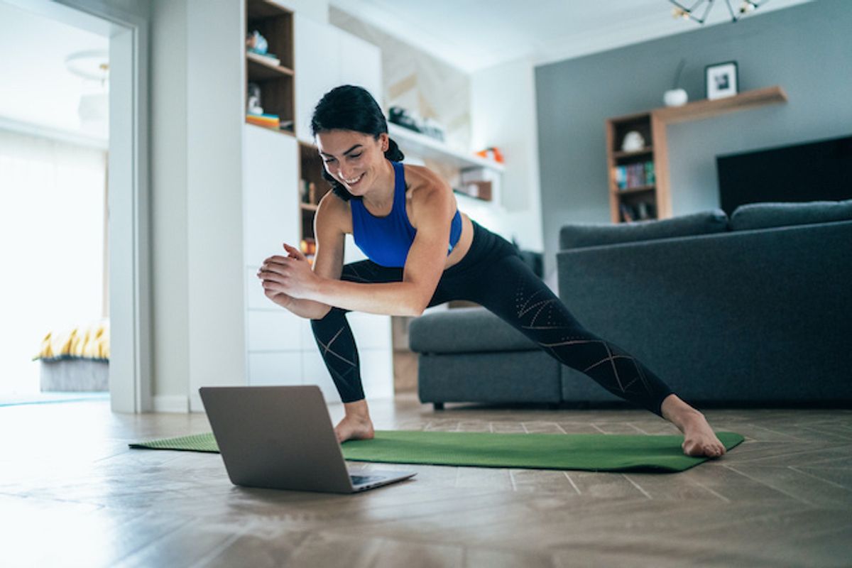 A woman exercising in front of a computer