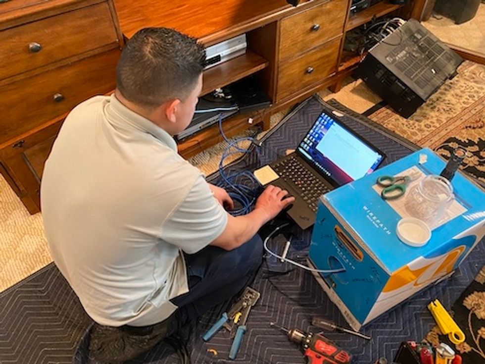 Control4 installer setting up devices on  a comper