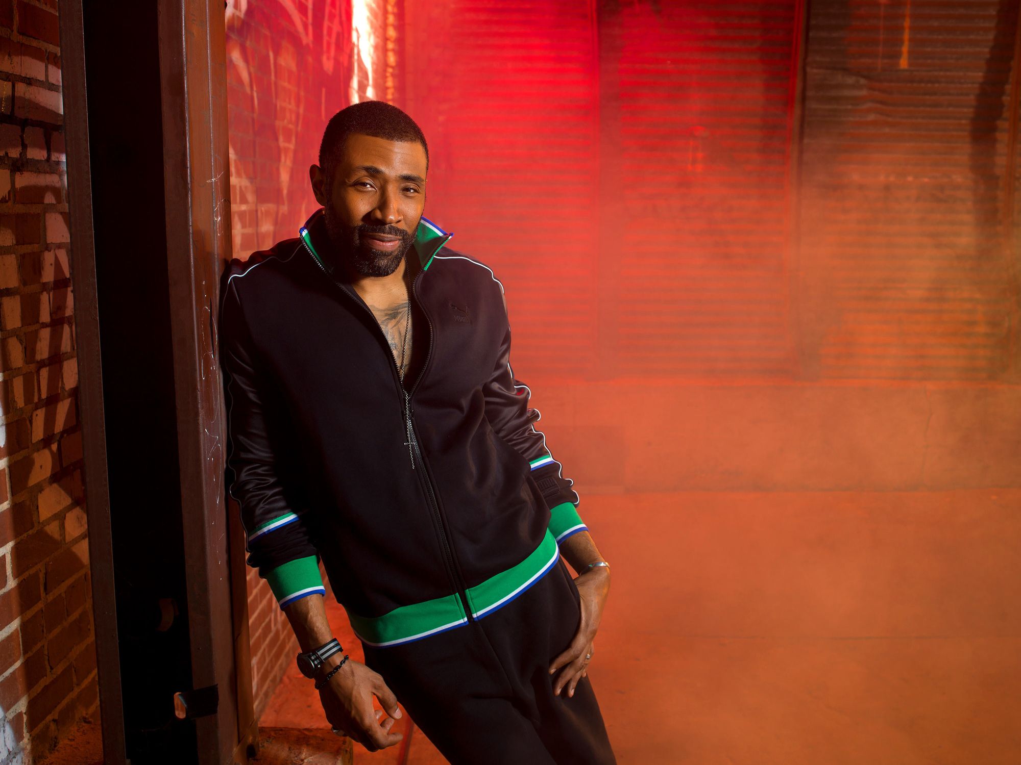 Actor Cress Williams leaning against a wall.