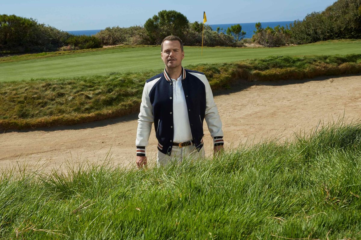 Chris ODonnell in a bomber jacket standing on a gold course