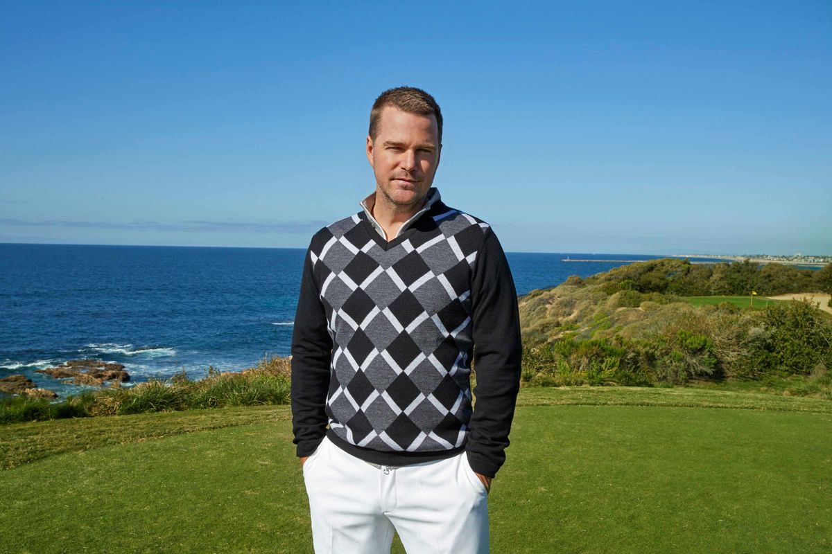 Chris O'Donnell staring ahead in a black and white sweater with the ocean in the background