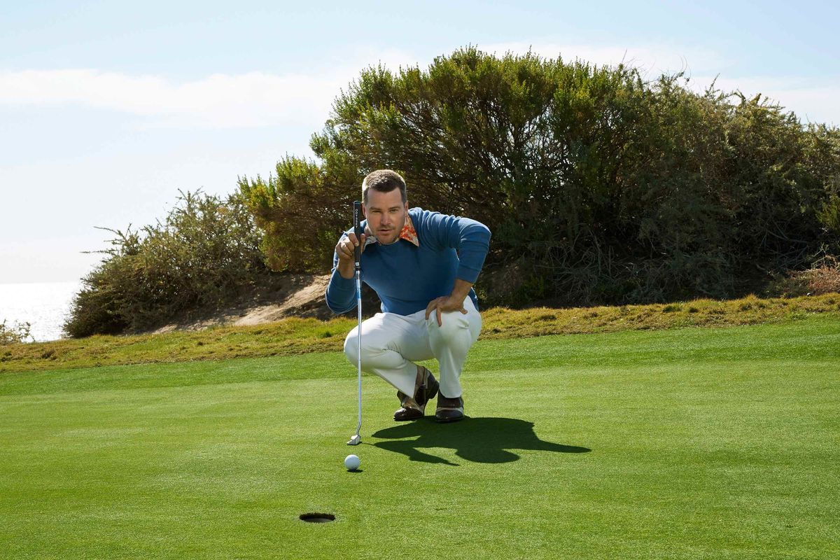 Chris O'Donnell squatting near a hole on a golf course