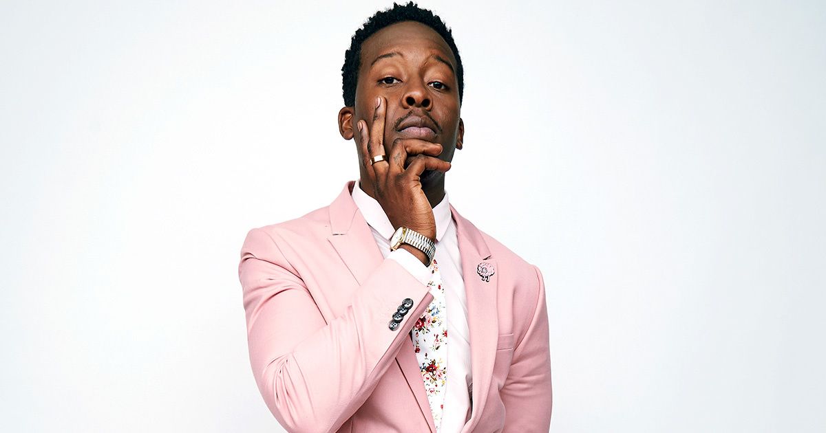 Actor Brandon Micheal Hall in a pink suit.