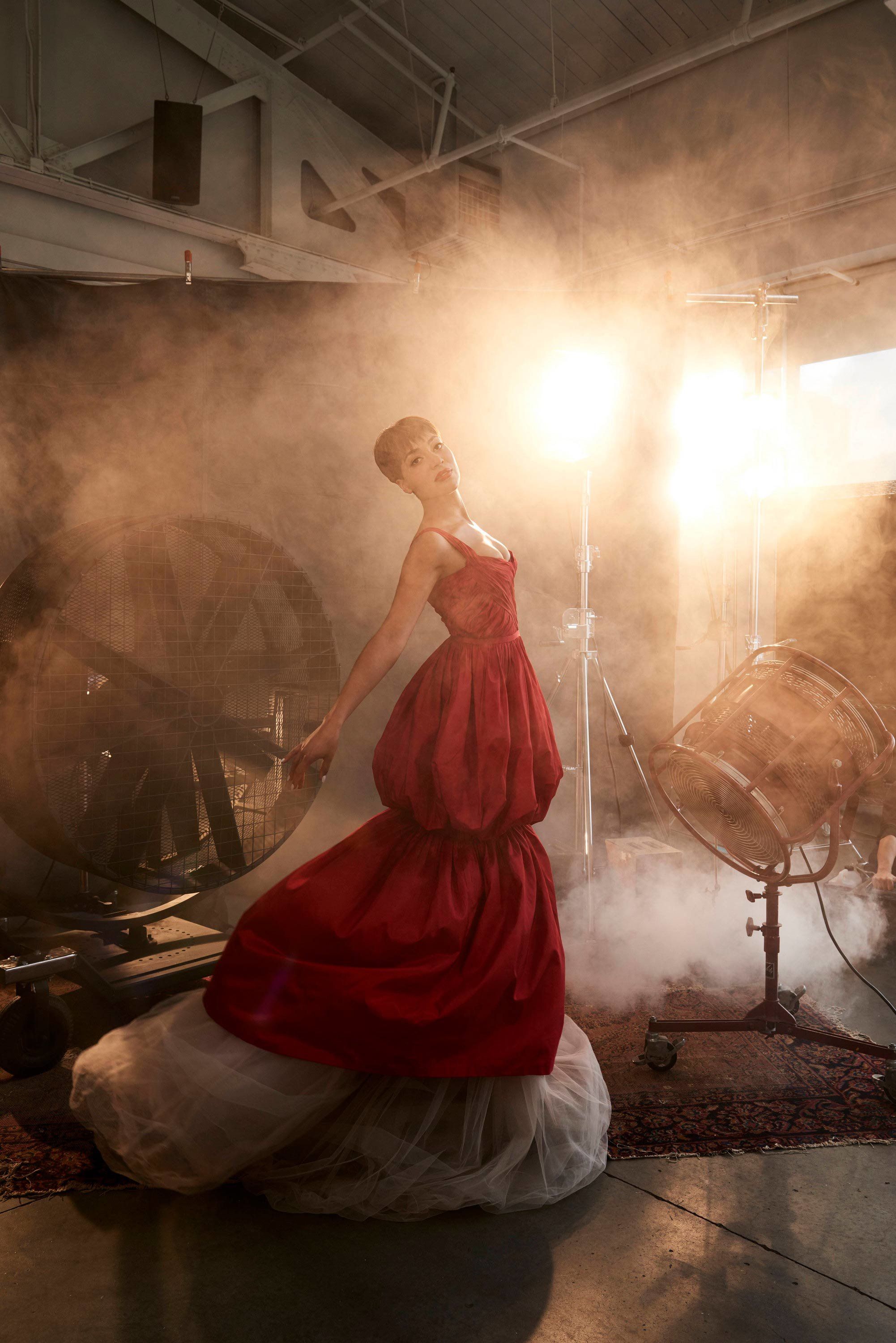 Actress Cush Jumbo posing in red designer gown.