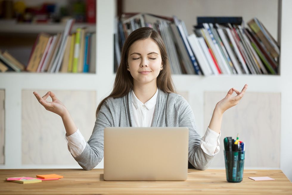 Young professional uses a mobile app to mediate while on a break from work.