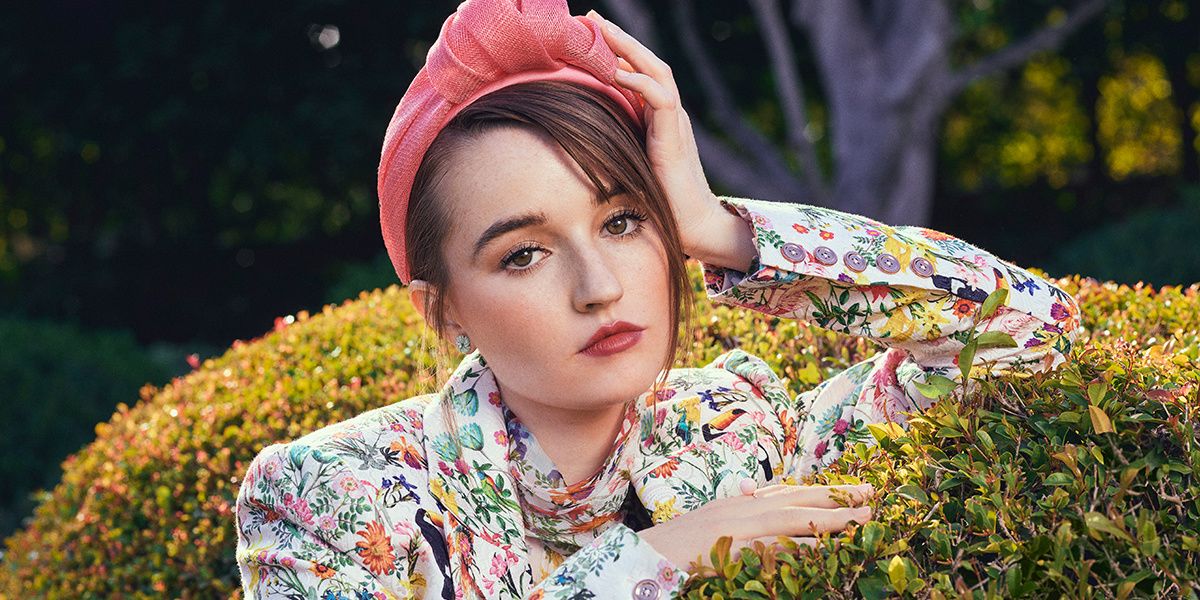 Close-up portrait of actress Kaitlyn Dever wearing a red headband.
