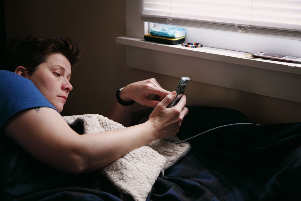 Person in bed looking at phone notifications