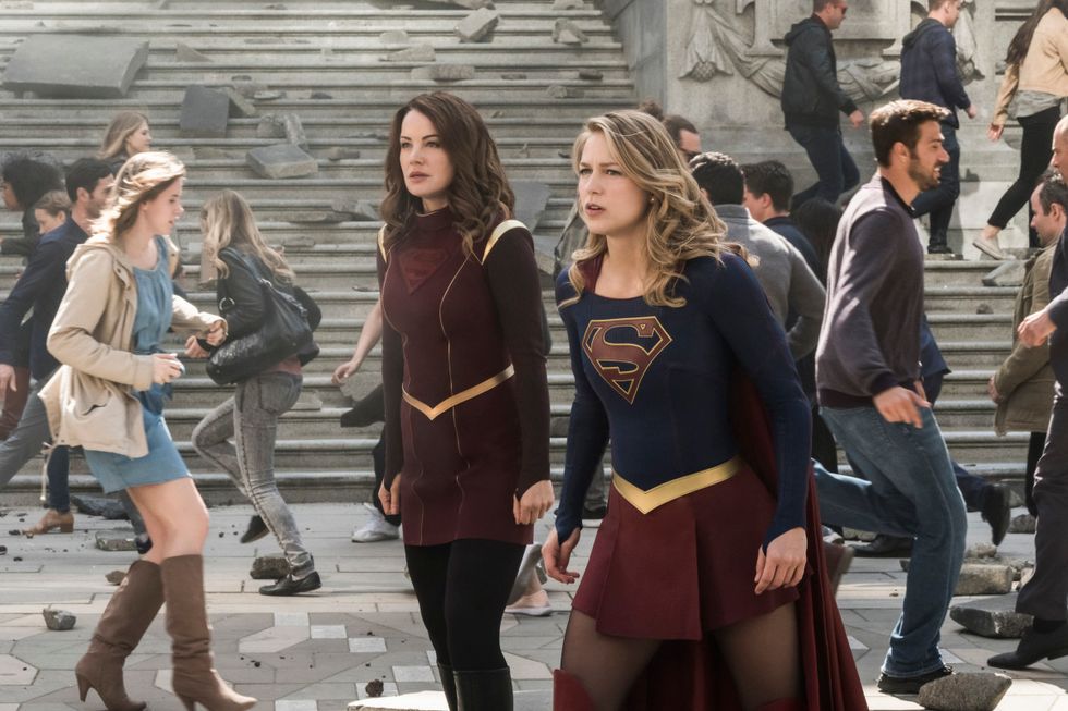 Melissa Benoist as Supergirl and her mother Erica Durance as Alura Zor El standing side by side as people rush around them