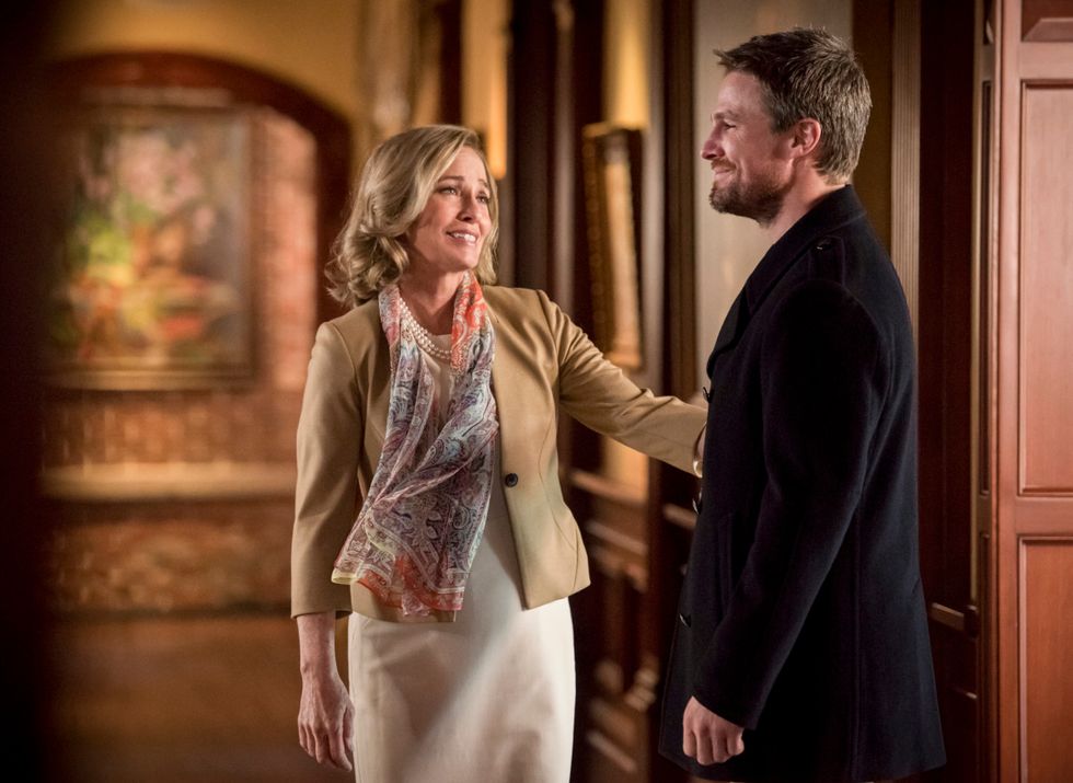 Susanna Thompson as Moria Queen holding her son Oliver Queen by the arm