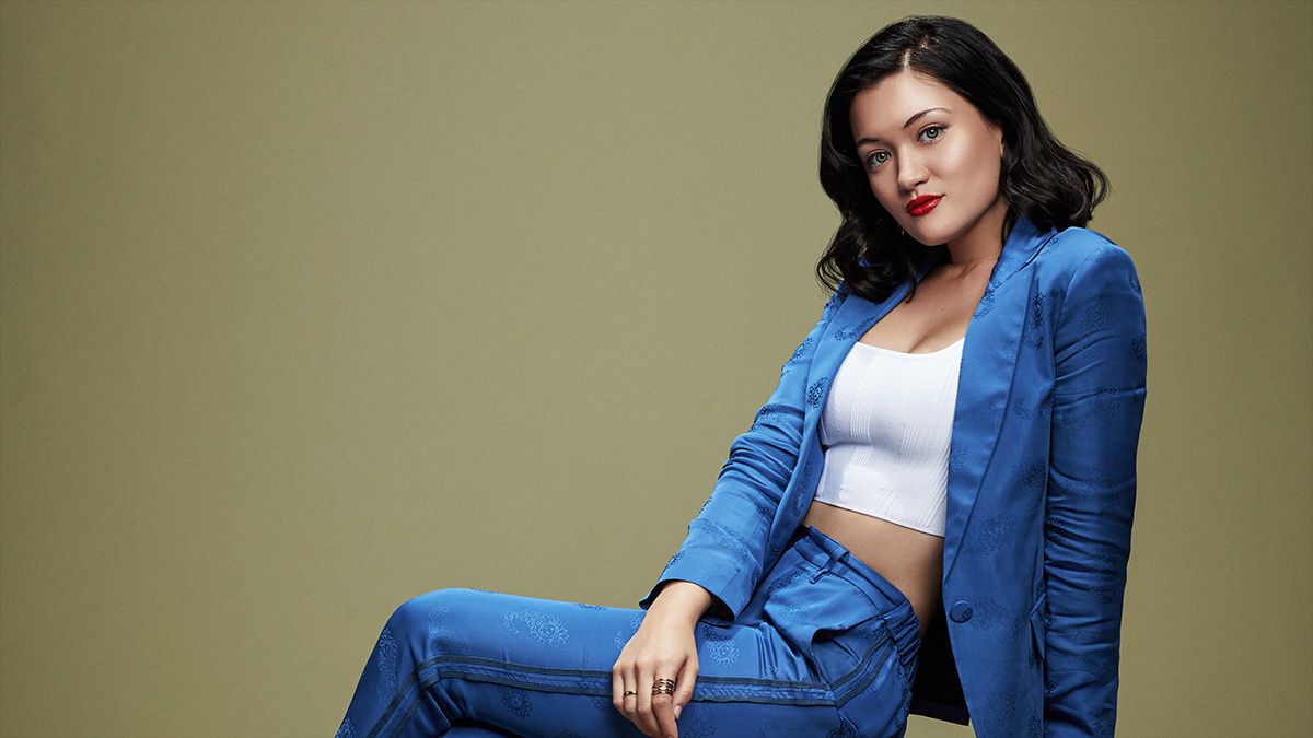 Actress Isa Briones reclines in blue silk jacket and pants.