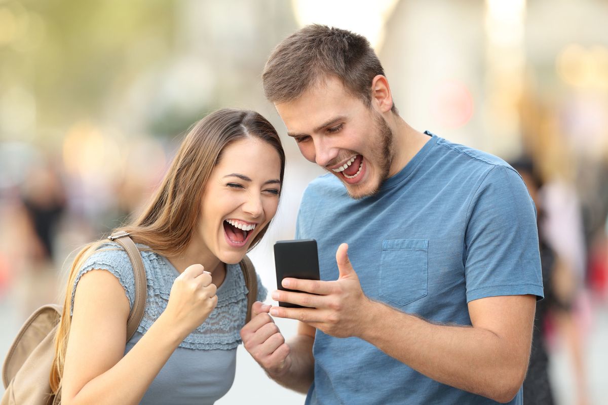 famous meme woman and man laugh and rejoice at man's iphone
