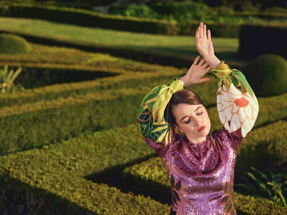 Actress Kaitlyn Dever wears a purple sequined dress with a jungle patterned sleeves.